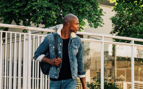 portrait-african-young-man-with-his-backpack-shoulder-looking-away